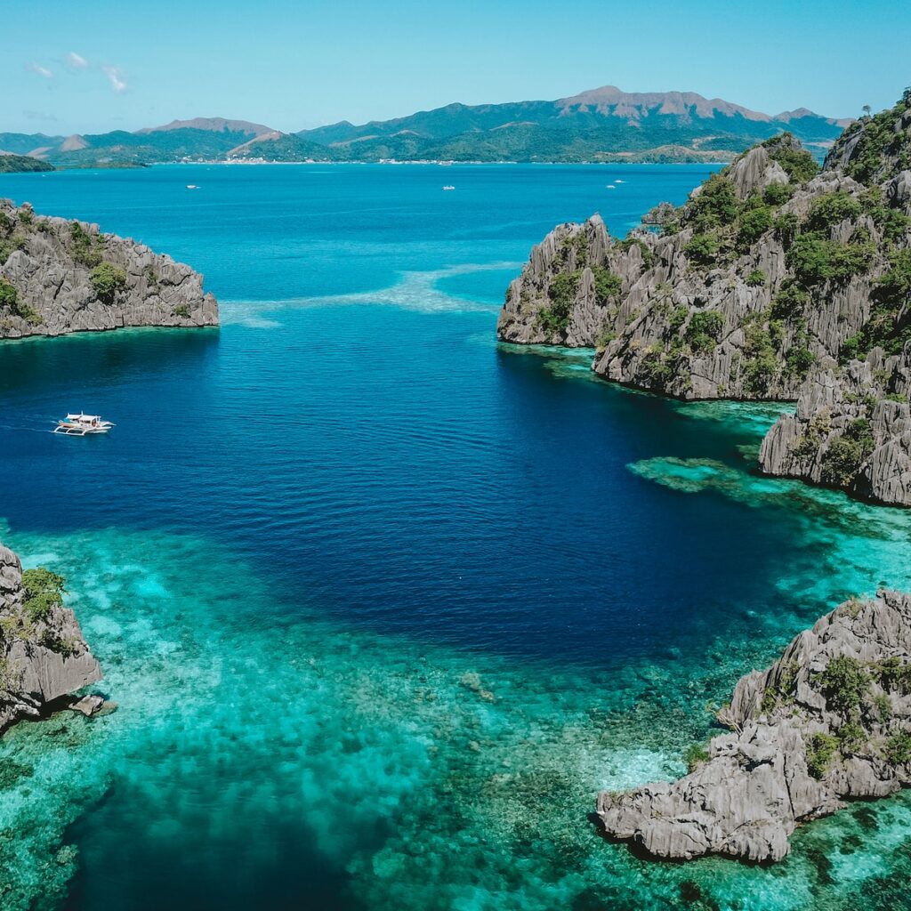 aerial photo of clear blue sea surrounded by mountains