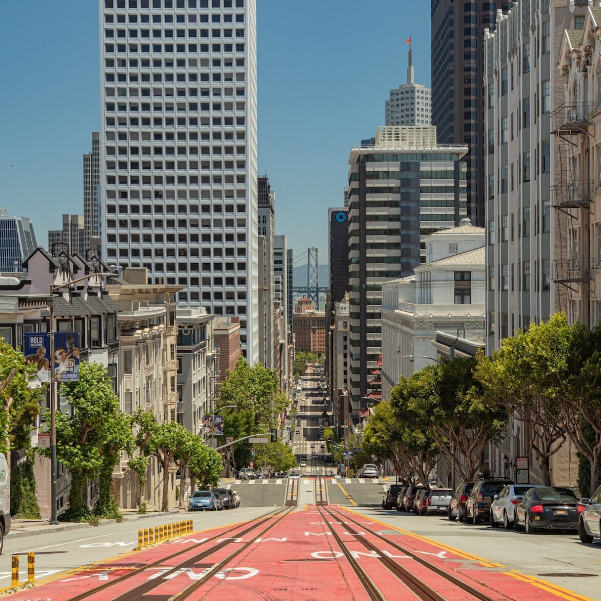 cars on road near high rise buildings during daytime